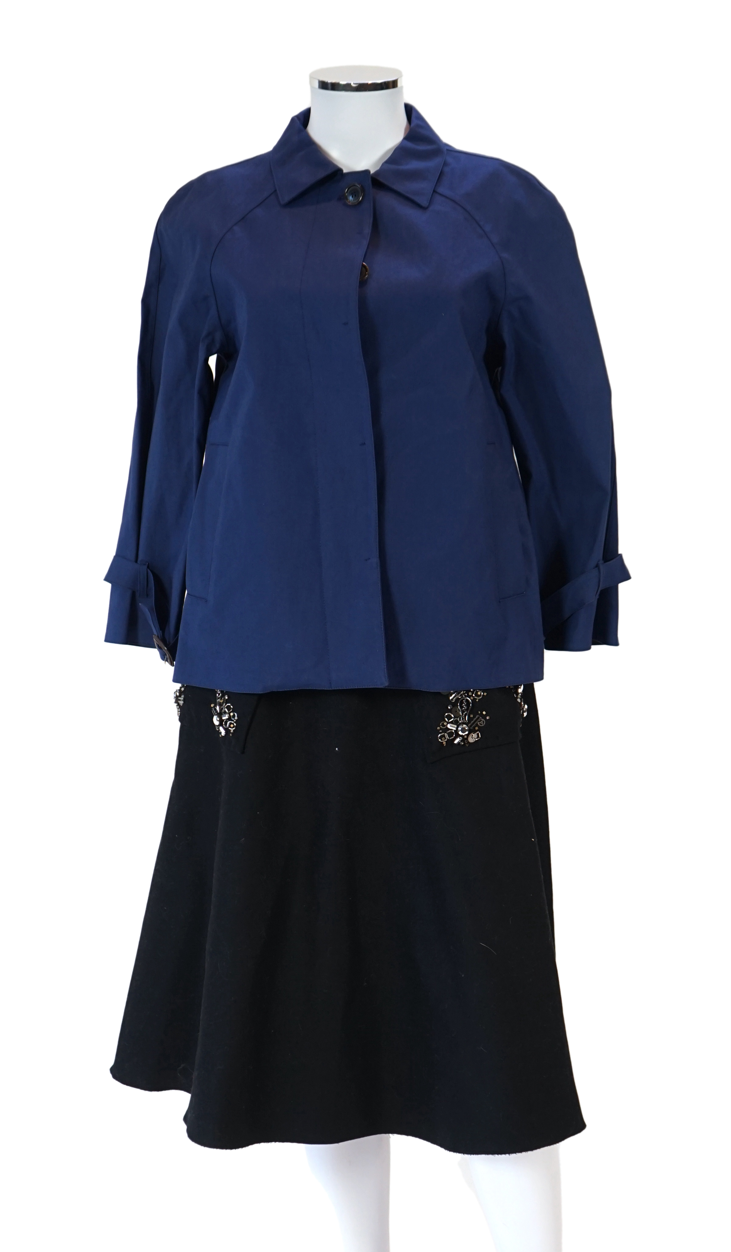 A Prada black A line wool skirt with silver embellishment on the pockets, a blue cotton canvas short swing raincoat and a black pair of wool suit trousers, all size 42